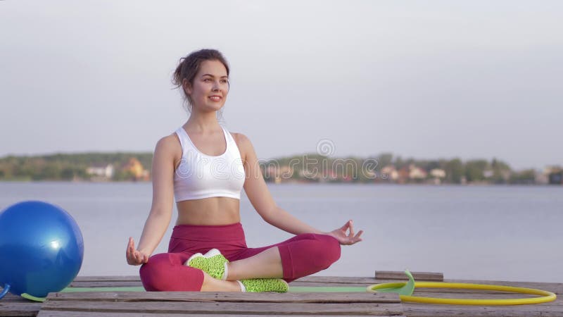 La thérapie de yoga, jeune beau yogi femelle en position de lotus médite et apprécie les calmnes spirituels sur la nature
