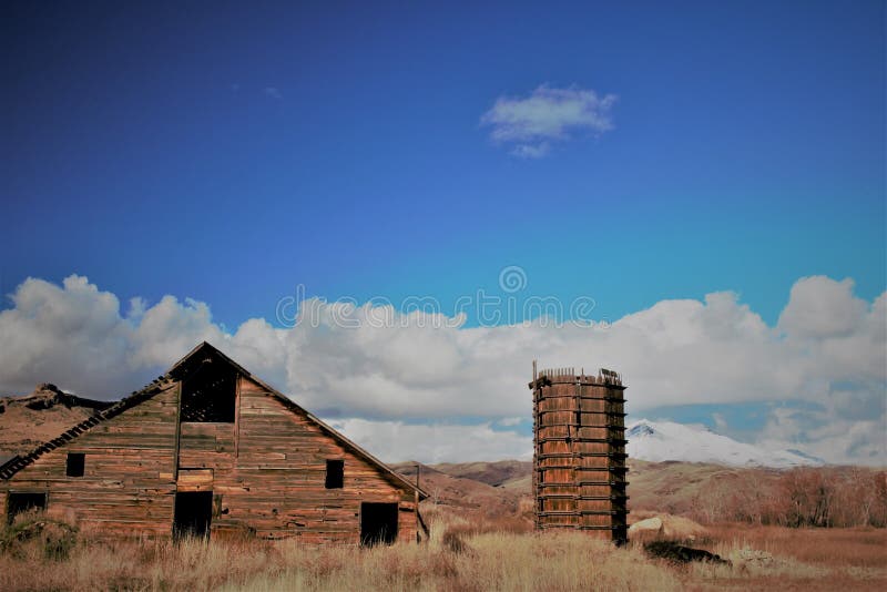 La torre rustica di acqua e del granaio, neve ha ricoperto la terra posteriore della montagna immagini stock La torre rustica di acqua e del granaio, neve ha ricoperto la terra posteriore della montagna immagini stock