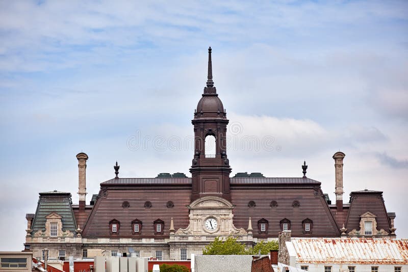 La tour, l'horloge et le toit de l'hôtel de ville de Montréal hotel de ville contre le ciel nuageux lumineux à vieux Montréal images stock La tour, l'horloge et le toit de l'hôtel de ville de Montréal hotel de ville contre le ciel nuageux lumineux à vieux Montréal images stock