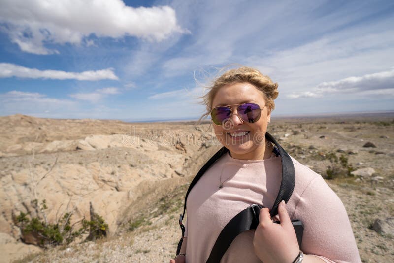 La touriste 20s de femme pose aux bad-lands de Borrego donnent sur en parc d'état de désert d'Anza Borrego dans CA photographie stock La touriste 20s de femme pose aux bad-lands de Borrego donnent sur en parc d'état de désert d'Anza Borrego dans CA photographie stock