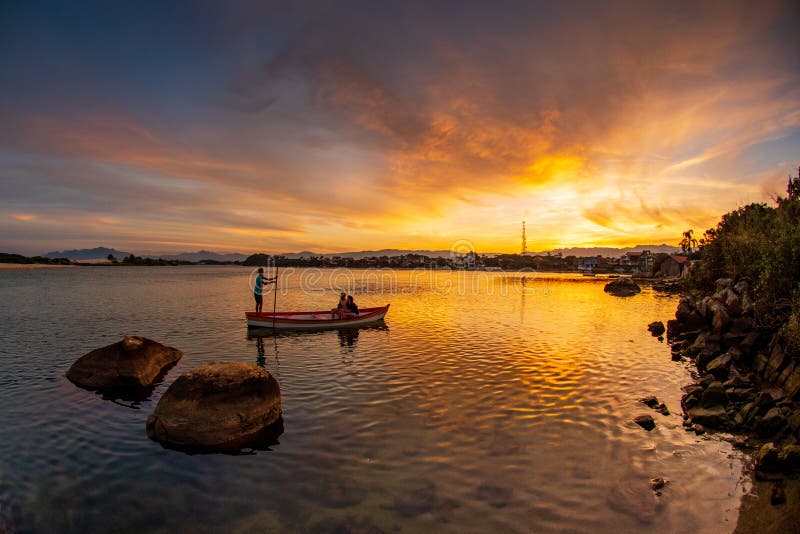 La travesía de la canoa en la puesta del sol en Guarda hace la playa de Embau - Santa Catarina Brazil fotografía de archivo La travesía de la canoa en la puesta del sol en Guarda hace la playa de Embau - Santa Catarina Brazil fotografía de archivo
