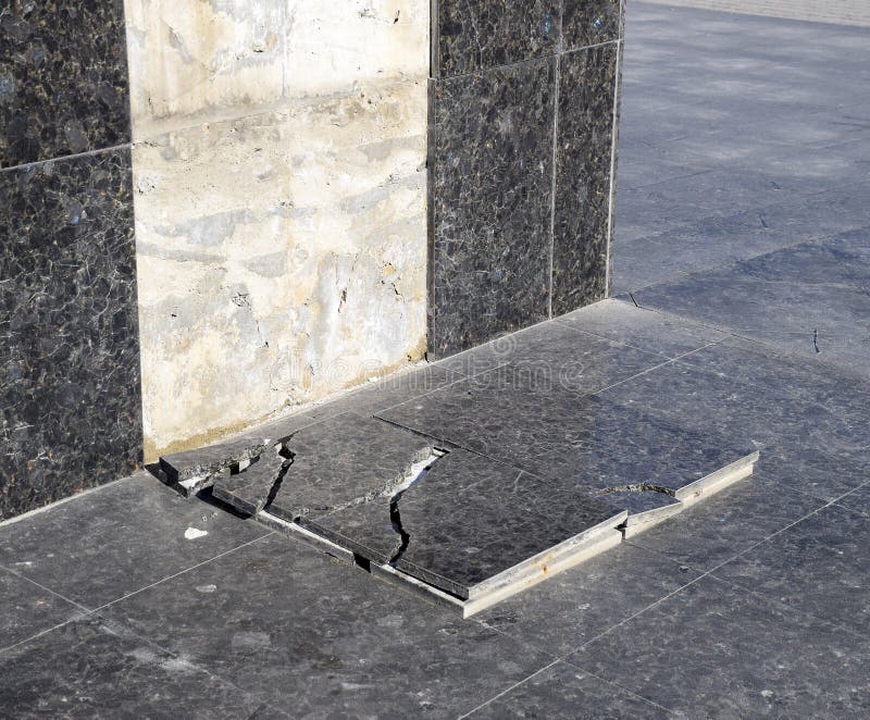 La tuile de marbre ruinée qui est tombée de la base du monument image stock La tuile de marbre ruinée qui est tombée de la base du monument image stock