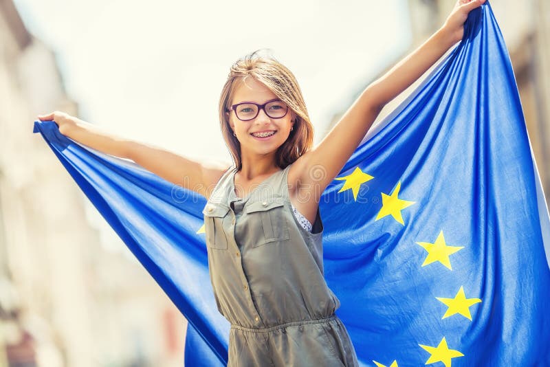 La UE señala por medio de una bandera Muchacha feliz linda con la bandera de la unión europea Adolescente joven que agita con la fotos de archivo libres de regalías La UE señala por medio de una bandera Muchacha feliz linda con la bandera de la unión europea Adolescente joven que agita con la fotos de archivo libres de regalías