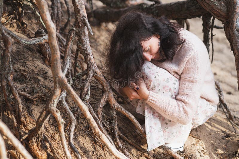 La unidad del hombre y la naturaleza. foto creativa de una niña entre las raíces de los árboles. el hombre es parte de la naturale fotos de archivo