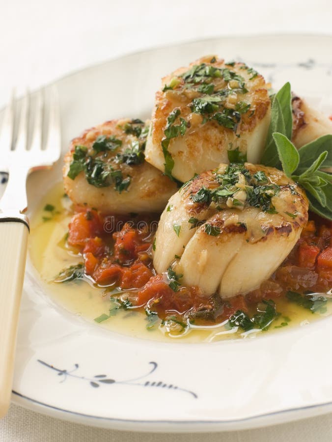 La vaschetta ha fritto i pettini Piperade ed il burro di aglio fotografie stock La vaschetta ha fritto i pettini Piperade ed il burro di aglio fotografie stock