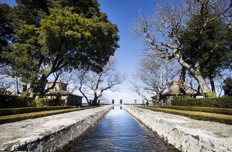 La vecchia fontana di pietra lungamente gradisce un fiume in un giardino del Mannerist fotografia stock La vecchia fontana di pietra lungamente gradisce un fiume in un giardino del Mannerist fotografia stock
