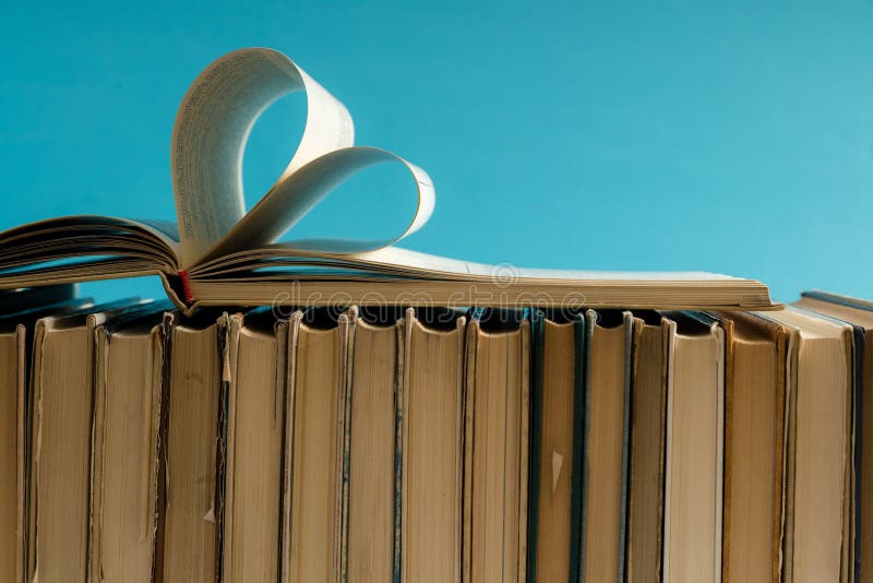 La vecchia pagina del libro della copertina rigida decora a forma del cuore per amore in val fotografie stock La vecchia pagina del libro della copertina rigida decora a forma del cuore per amore in val fotografie stock