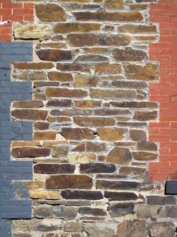 La vecchia pietra ed il mattone dipinto hanno decorato la parete immagine stock La vecchia pietra ed il mattone dipinto hanno decorato la parete immagine stock