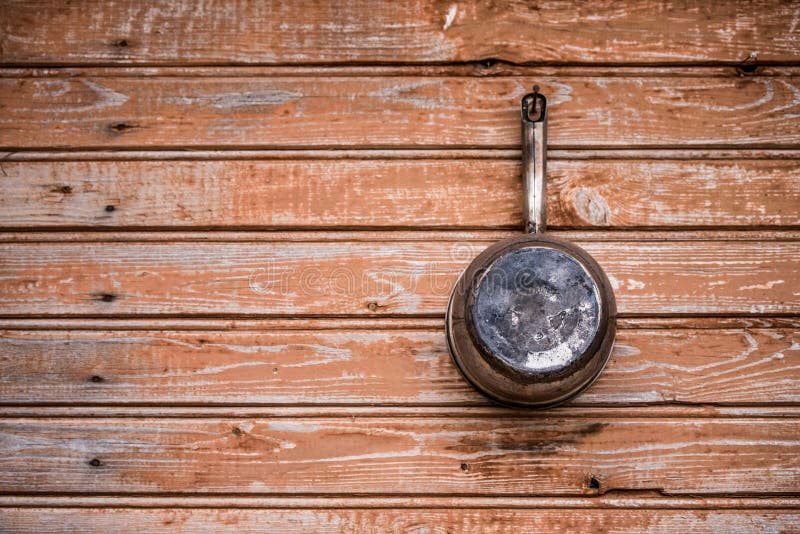 old aluminum ladle lies on a wooden board background. old aluminum ladle lies on a wooden board background