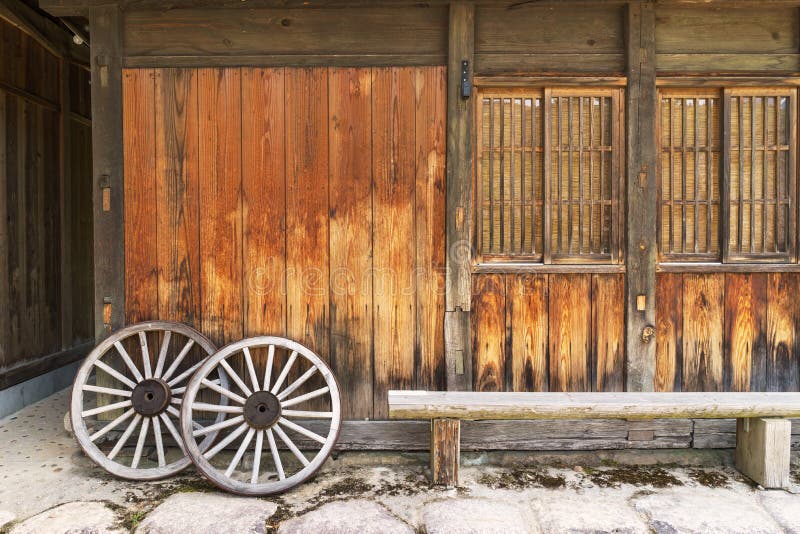 La vieille maison en bois et le chariot en bois de vintage roulent photo stock La vieille maison en bois et le chariot en bois de vintage roulent photo stock