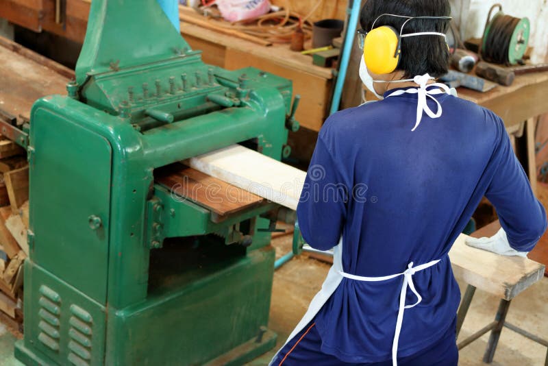 La visión superior, trabajador está trabajando con el cepillado de la máquina de madera Él está llevando el equipo de seguridad e fotos de archivo libres de regalías La visión superior, trabajador está trabajando con el cepillado de la máquina de madera Él está llevando el equipo de seguridad e fotos de archivo libres de regalías