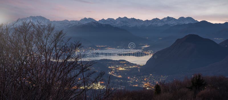 La vista aérea del lago Maggiore en la oscuridad con la nieve capsuló las montañas, Italia fotos de archivo La vista aérea del lago Maggiore en la oscuridad con la nieve capsuló las montañas, Italia fotos de archivo