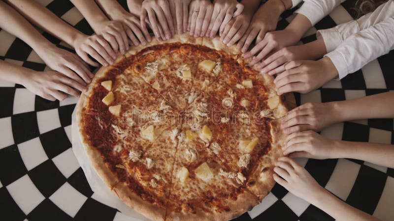 La vista de los fingeres del ` s de los niños que se mueven síncrono y ayuna a la pizza en un centro almacen de video