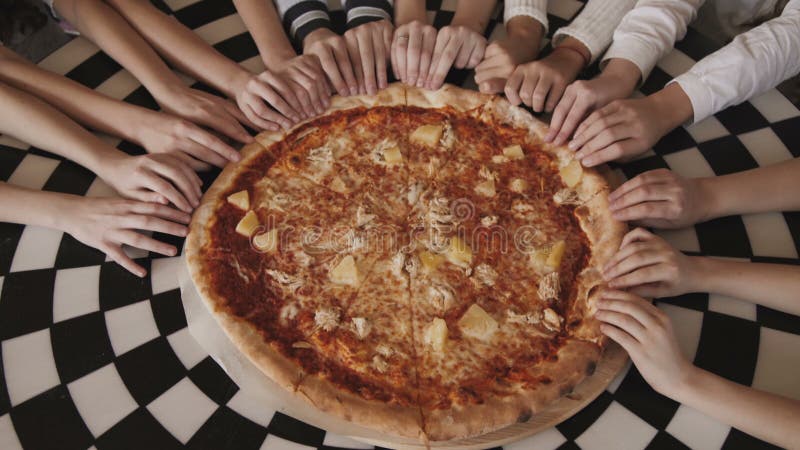 La vista de los fingeres del ` s de los niños que se mueven síncrono y ayuna a la pizza en un centro almacen de metraje de vídeo