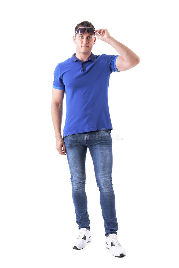 La vista frontale di giovane uomo casuale adulto rimuove gli occhiali da sole e l'esame della distanza immagine stock libera da diritti La vista frontale di giovane uomo casuale adulto rimuove gli occhiali da sole e l'esame della distanza immagine stock libera da diritti