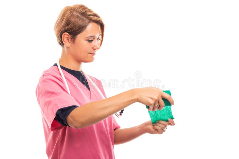 La vista lateral del rosa que lleva del veterinario de sexo femenino friega usando el vendaje verde imagen de archivo La vista lateral del rosa que lleva del veterinario de sexo femenino friega usando el vendaje verde imagen de archivo