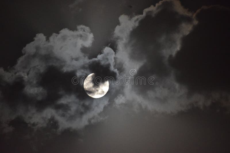 La vista sulla luna piena durante la notte nuvolosa nel cielo