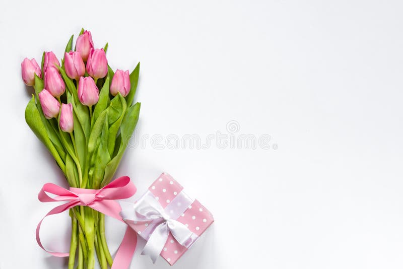 La vista superior del ramo rosado de los tulipanes, envuelta con la cinta rosada y el rosa punteó la caja de regalo sobre el fond fotografía de archivo libre de regalías La vista superior del ramo rosado de los tulipanes, envuelta con la cinta rosada y el rosa punteó la caja de regalo sobre el fond fotografía de archivo libre de regalías