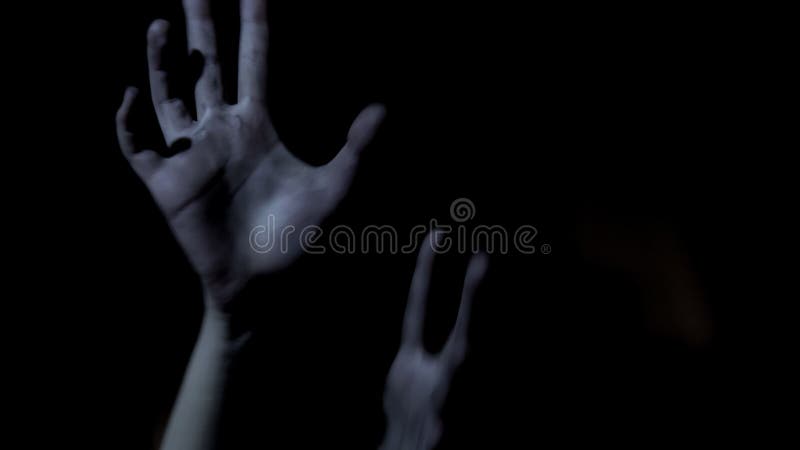 La vittima passa l'allungamento fuori nell'oscurità, elemosinante l'aiuto, giallo spaventoso fotografie stock libere da diritti La vittima passa l'allungamento fuori nell'oscurità, elemosinante l'aiuto, giallo spaventoso fotografie stock libere da diritti