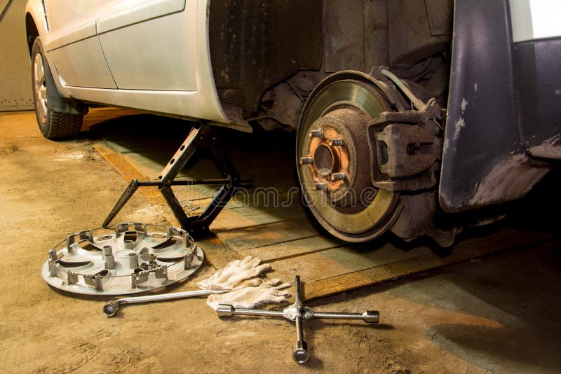 La voiture changeante de mécanicien roulent dedans le garage Homme échangeant le pneu Service de pneu photo libre de droits La voiture changeante de mécanicien roulent dedans le garage Homme échangeant le pneu Service de pneu photo libre de droits