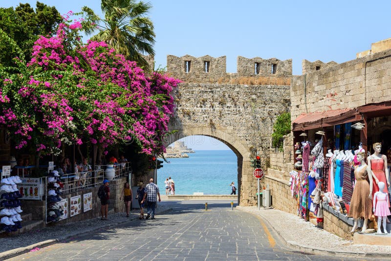La voûte antique dans le vieux mur de la ville de Rhodes avec la bouganvillée pourpre fleurit dans la ville de Rhodes sur l'île d photos stock La voûte antique dans le vieux mur de la ville de Rhodes avec la bouganvillée pourpre fleurit dans la ville de Rhodes sur l'île d photos stock