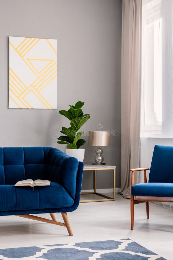 La vraie photo de l'intérieur gris-clair de salon avec l'usine fraîche, fenêtre avec drape, peinture géométrique et livre ouvert photographie stock libre de droits La vraie photo de l'intérieur gris-clair de salon avec l'usine fraîche, fenêtre avec drape, peinture géométrique et livre ouvert photographie stock libre de droits