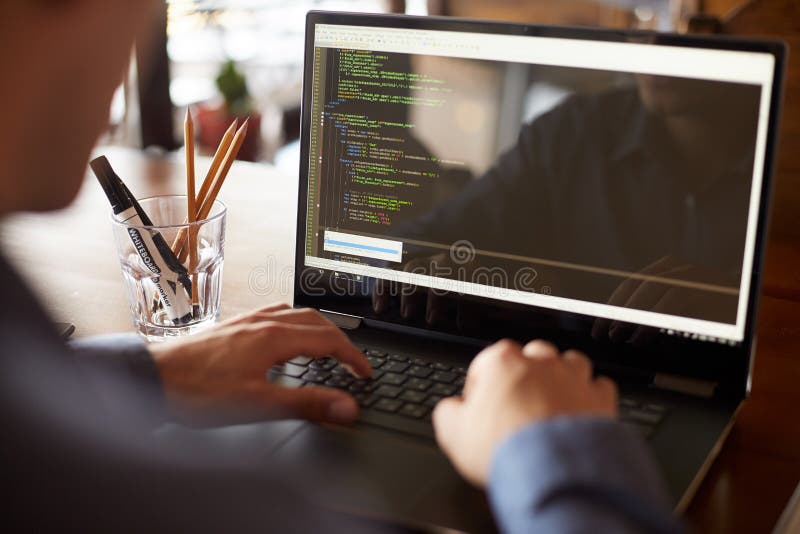 La vue arrière au-dessus de l'épaule a tiré du programmeur de promoteur avec l'ordinateur portable Programmez le code et les donn photos libres de droits La vue arrière au-dessus de l'épaule a tiré du programmeur de promoteur avec l'ordinateur portable Programmez le code et les donn photos libres de droits