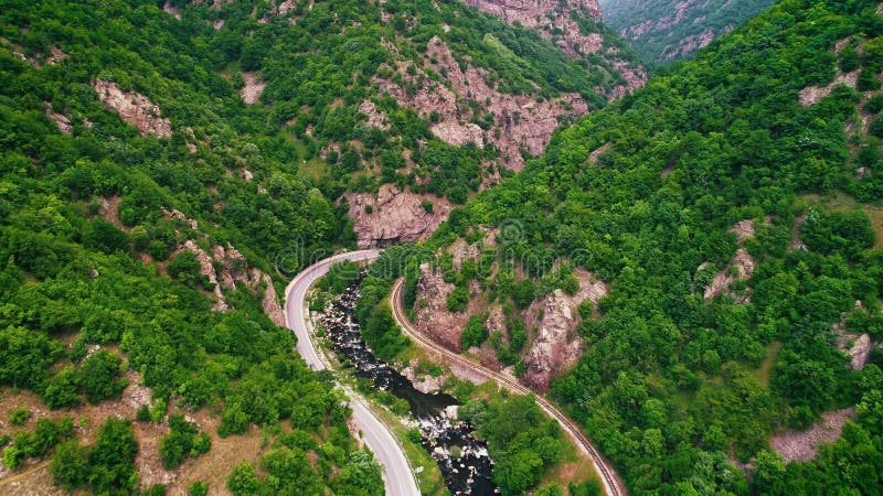 La vue aérienne du bourdon au-dessus de la route de montagne et les courbes allant par la forêt aménagent en parc clips vidéos