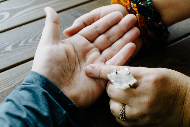 Top view of human hand and psychic or fortune teller explains lines on palm. Palmistry concept. Top view of human hand and psychic or fortune teller explains lines on palm. Palmistry concept