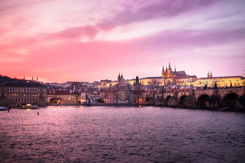 La vue panoramique du château de Prague, du Charles Bridge et du St Vitus Cathedral s'est reflétée en rivière de Vltava au crépus images stock La vue panoramique du château de Prague, du Charles Bridge et du St Vitus Cathedral s'est reflétée en rivière de Vltava au crépus images stock