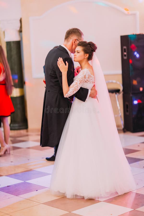 La vue verticale des nouveaux mariés avec du charme perfoming leur première danse dans le restaurant image stock