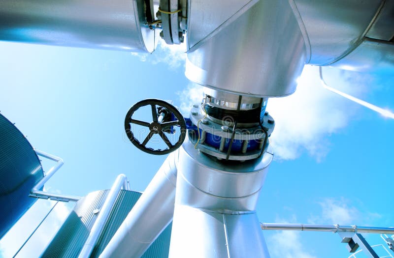 La zona industriale, l'acciaio canalizza le valvole contro cielo blu fotografia stock libera da diritti La zona industriale, l'acciaio canalizza le valvole contro cielo blu fotografia stock libera da diritti