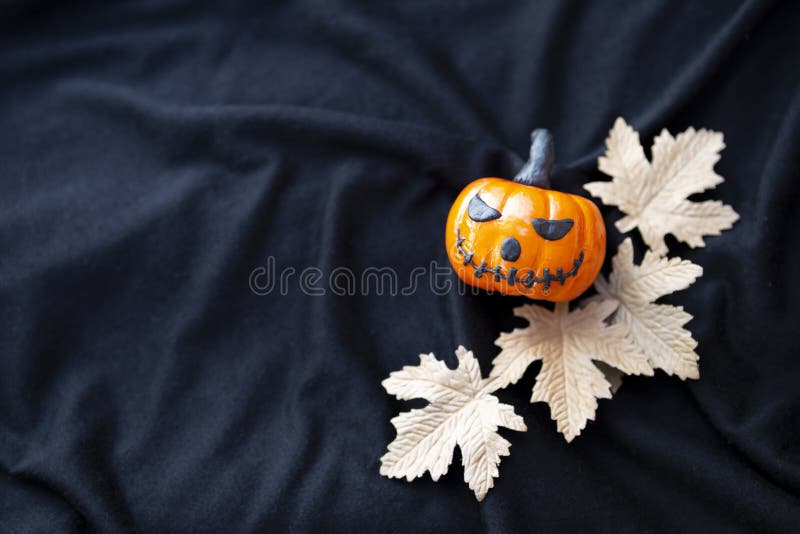La zucca divertente di Halloween di progettazione con carta va sul fondo nero di struttura del tessuto fotografia stock libera da diritti La zucca divertente di Halloween di progettazione con carta va sul fondo nero di struttura del tessuto fotografia stock libera da diritti