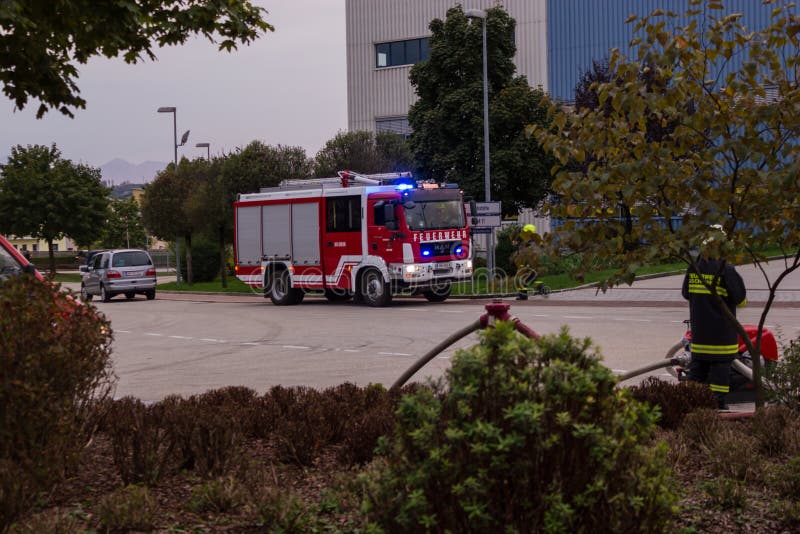 LAAKIRCHEN, AUSTRIA SEPTEMBER 24, 2015: Firefighters and fire truck with portable crane at fire in paper factory