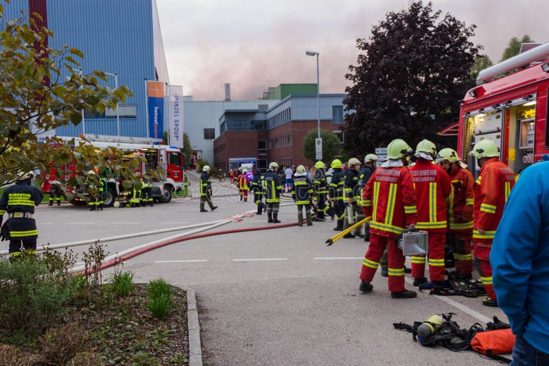 LAAKIRCHEN, AUSTRIA SEPTEMBER 24, 2015: Firefighters and fire truck with portable crane at fire in paper factory