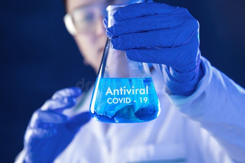 Lab worker holds flask with antiviral medicines stock photography