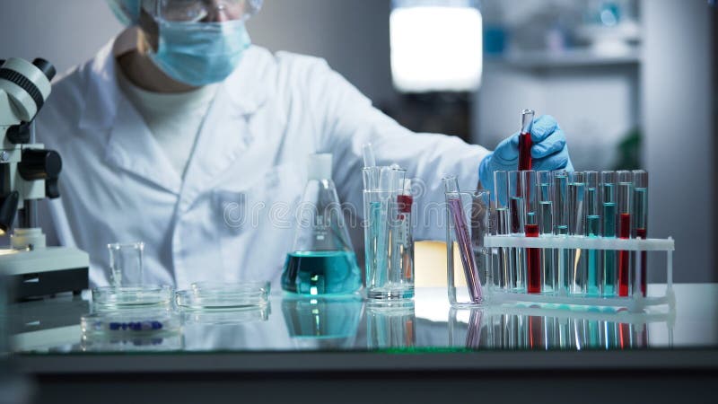 Labbarbetare som på plats sätter den medicinska blodprövkopian, når att ha undersökt för bottensatser royaltyfri bild Labbarbetare som på plats sätter den medicinska blodprövkopian, når att ha undersökt för bottensatser royaltyfri bild