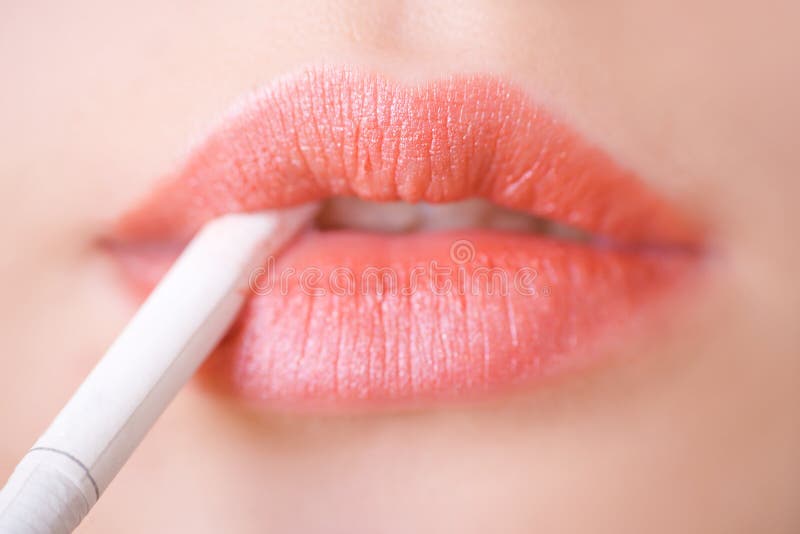 Labios de la mujer con un cigarrillo imagen de archivo Labios de la mujer con un cigarrillo imagen de archivo