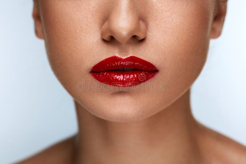 Labios hermosos de la mujer del primer con el lápiz labial rojo encendido Maquillaje de la belleza imágenes de archivo libres de regalías