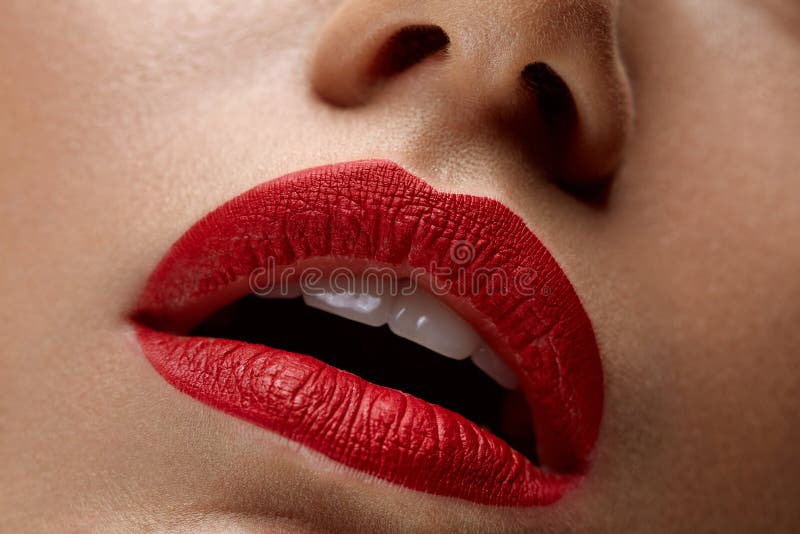 Labios hermosos de la mujer del primer con el lápiz labial rojo encendido Maquillaje de la belleza imagen de archivo libre de regalías