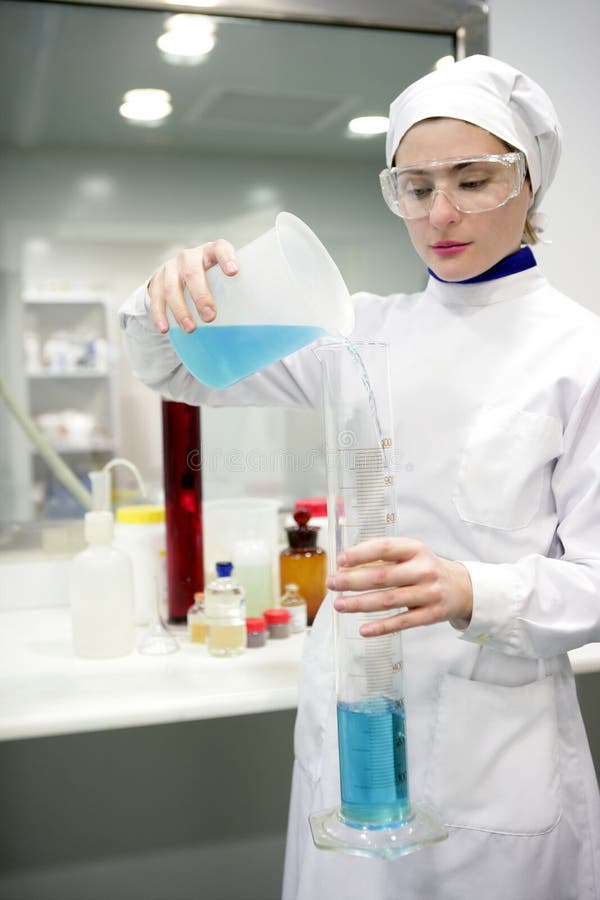 Laboratoire travaillant de femme, vase en verre à cylindre image libre de droits Laboratoire travaillant de femme, vase en verre à cylindre image libre de droits