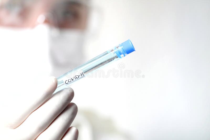 Laboratory assistant holding test tube of covid-19 virus vaccine