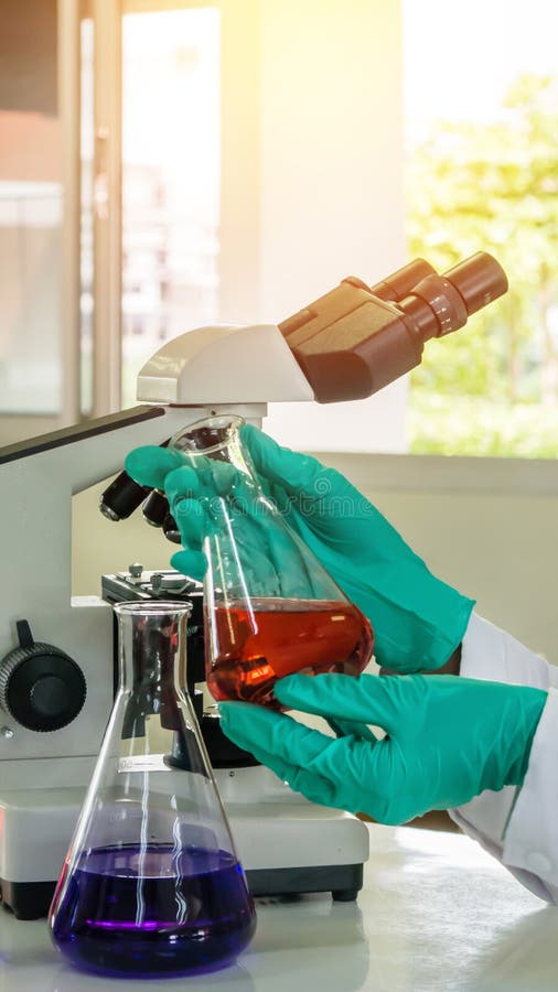 Laboratory Beaker In Analyst`s Hand In Plastic Glove. Stock Photo