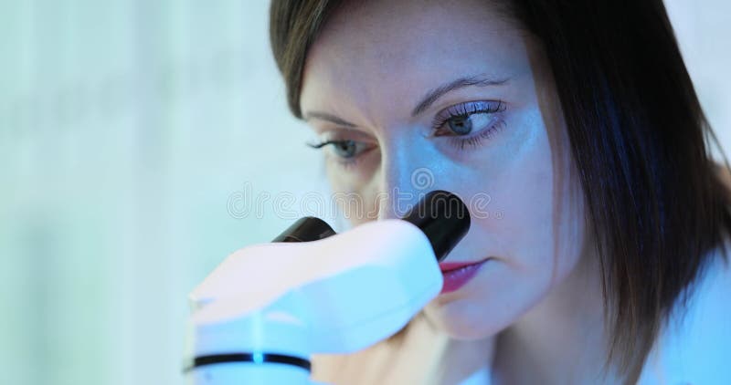 Laboratory technician examines specimen with microscope stock video