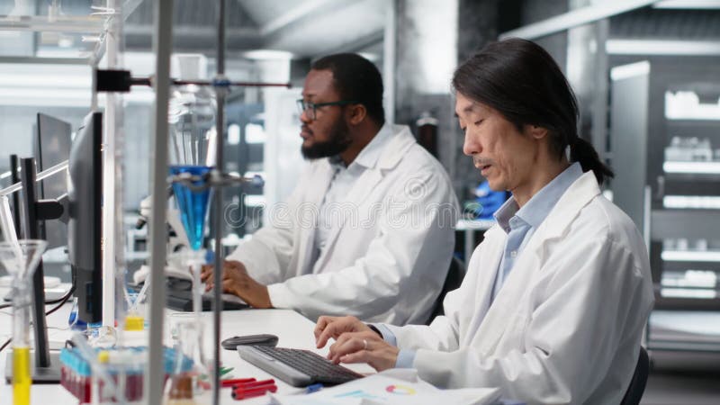 Laboratory technician uses computer app, doing research into human health stock video footage