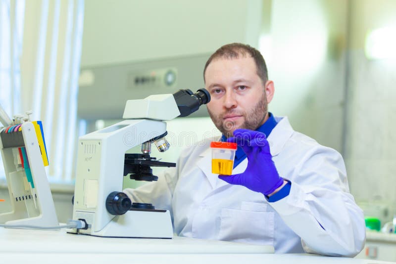 Laboratory Worker Performing Urinalysis Using Microscope and Laboratory