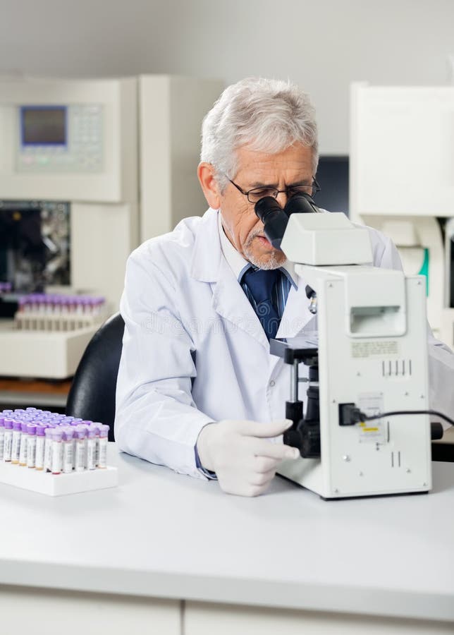 Laboratório masculino de Using Microscope In do cientista imagem de stock royalty free
