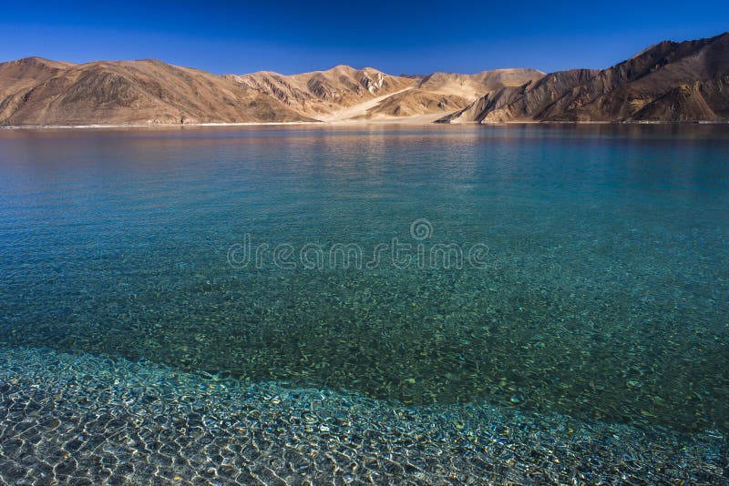 Lac avec l'eau bleue et le fond de montagnes photo libre de droits Lac avec l'eau bleue et le fond de montagnes photo libre de droits