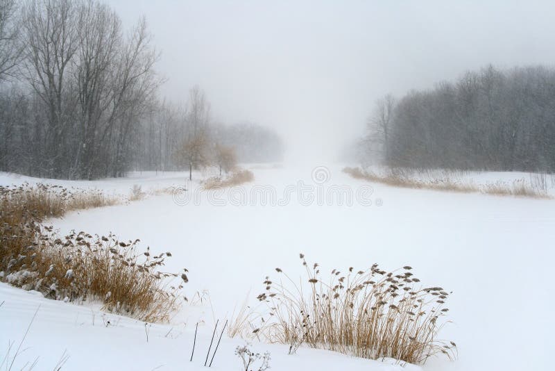 Lac en brume brumeuse de tempête de neige de l'hiver image libre de droits Lac en brume brumeuse de tempête de neige de l'hiver image libre de droits