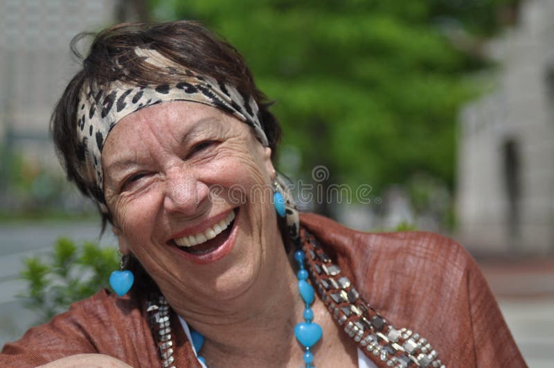 Elderly woman is laughing, with a huge smile, and looking at the camera. She has a confident and happy expression in her face. Elderly woman is laughing, with a huge smile, and looking at the camera. She has a confident and happy expression in her face.